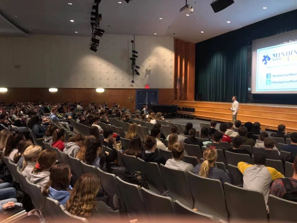Students in an auditorium watching Evan speak