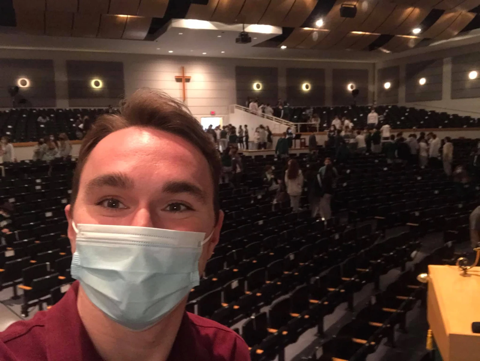 Evan taking a photo with an auditorium audience behind him