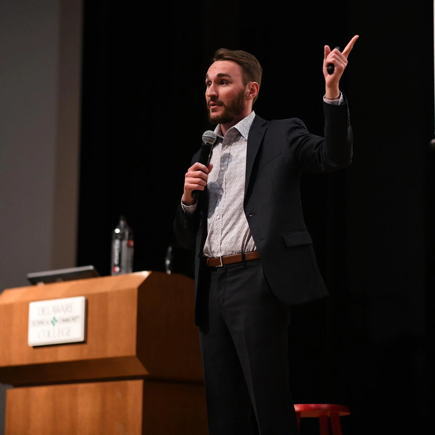 Evan Transue speaking on stage with a microphone